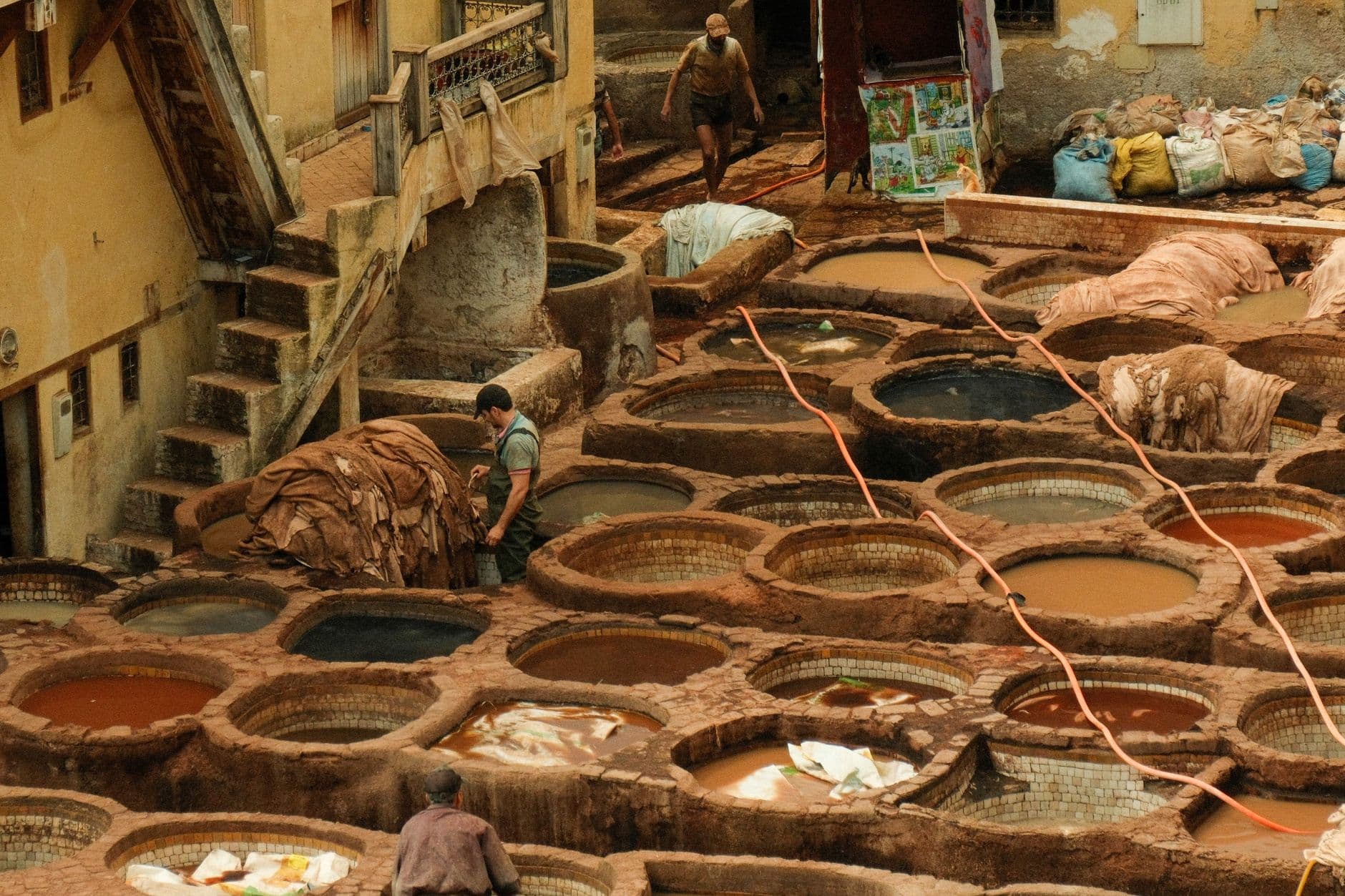Aerial view of vibrant traditional tanneries in Fes, Morocco, showcasing the tanning process.